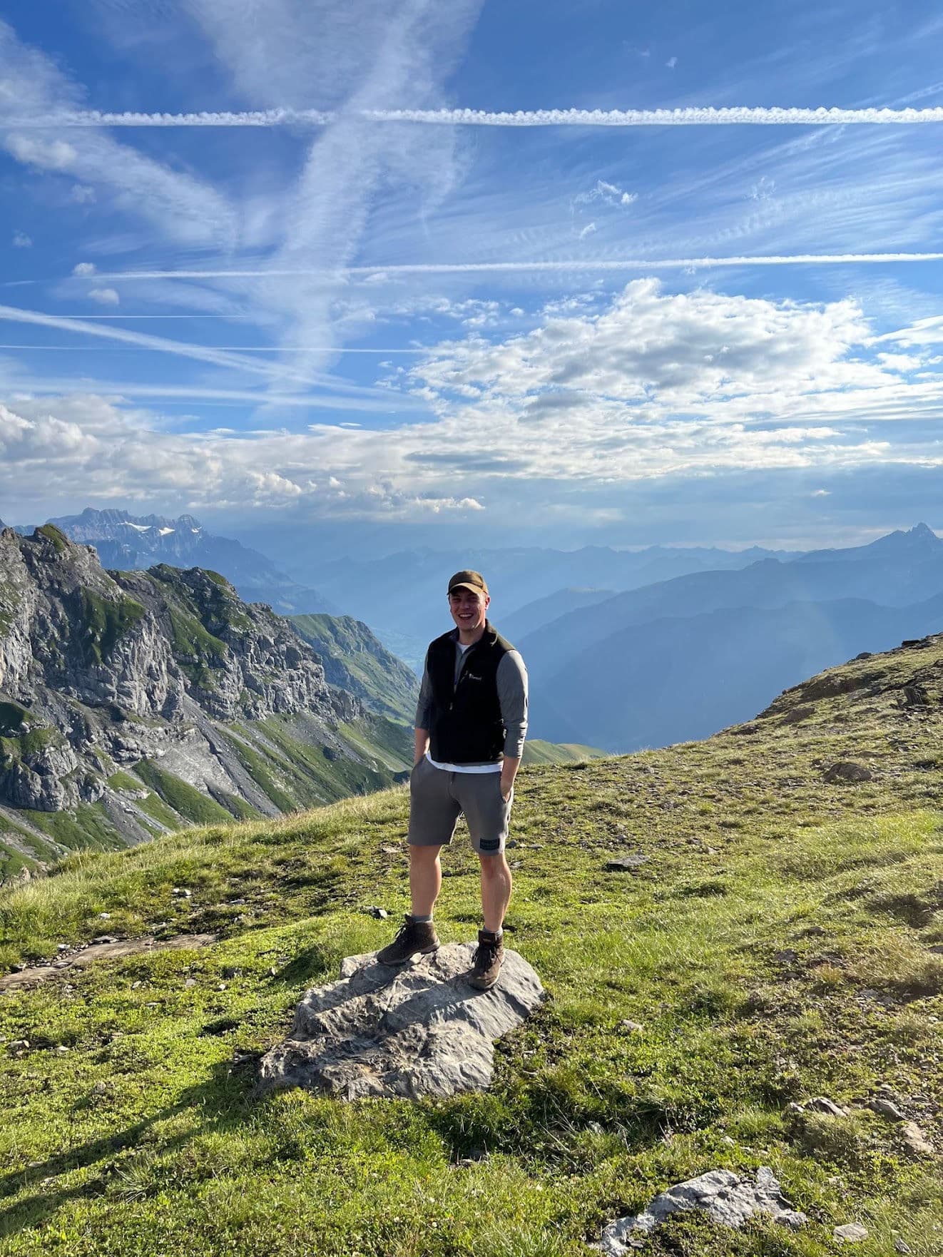 Sebastian steht auf einem Felsen vor einer Bergkette